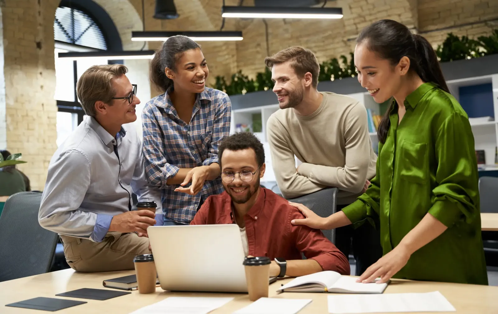 Smiling colleagues looking at a laptop