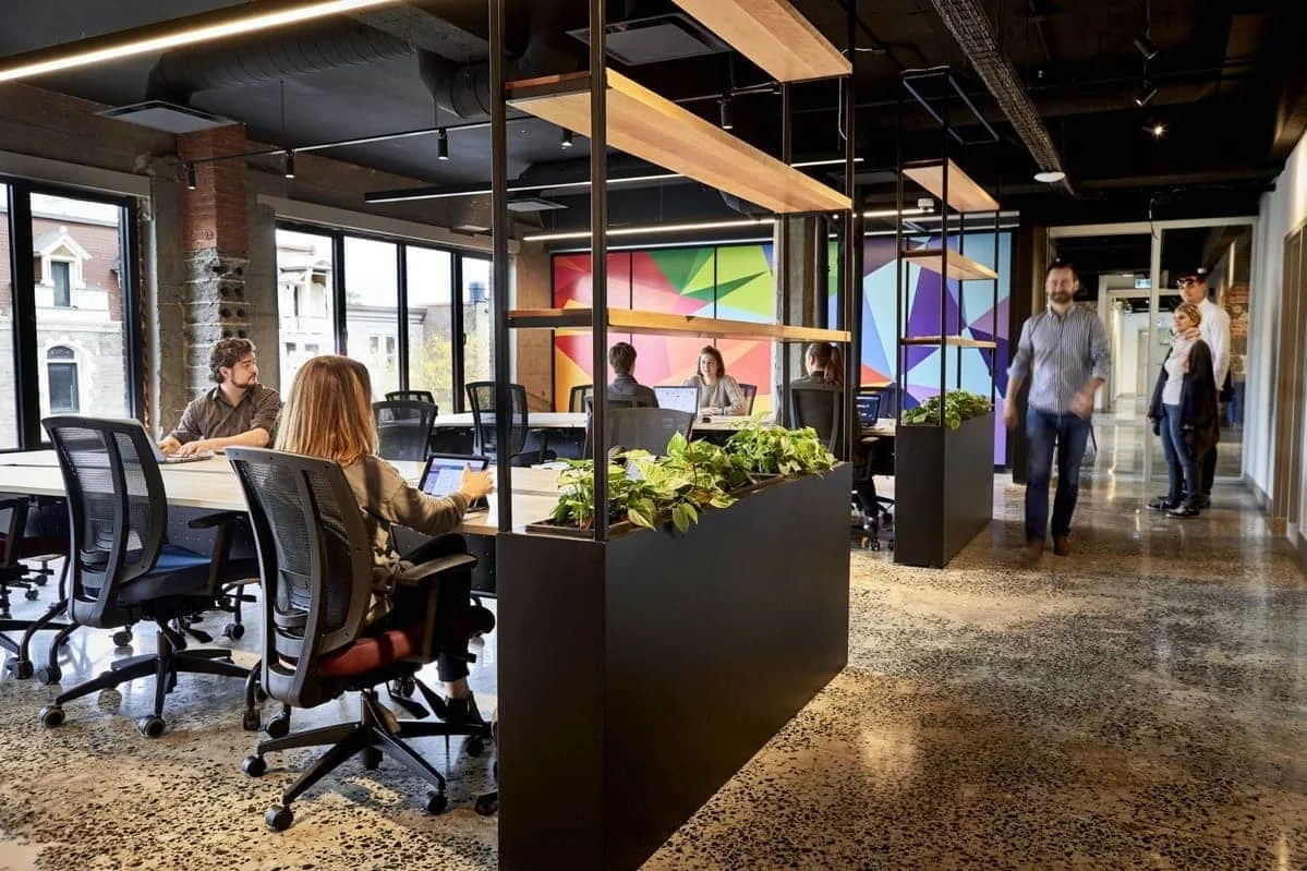 Bright collaborative workspace with brick walls and a colorful mural