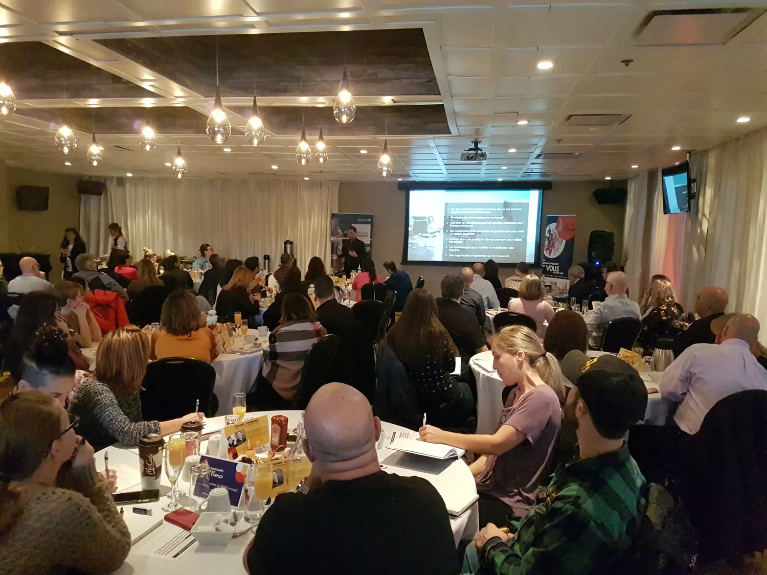 A packed room of managers at an Amélio conference