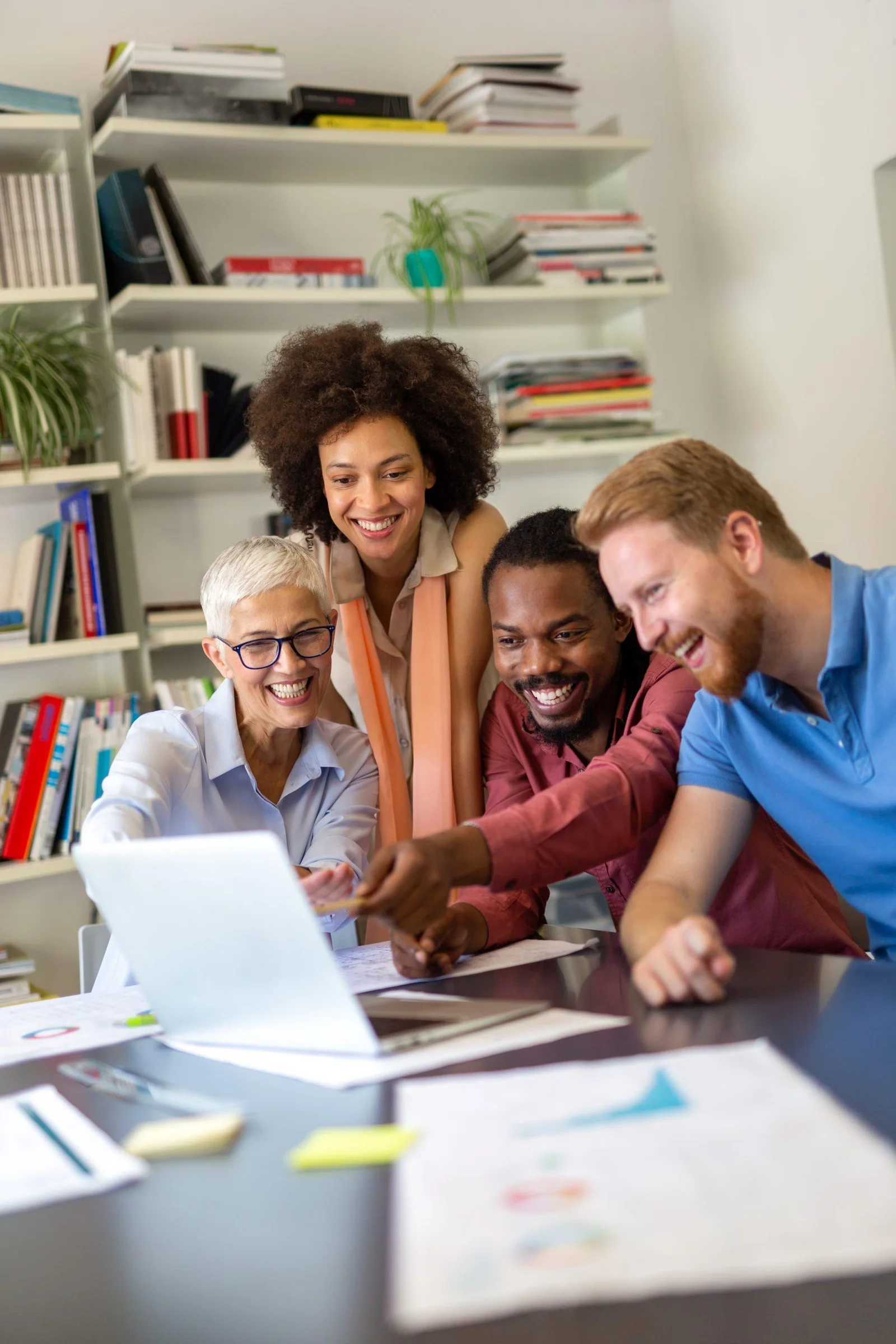 A smiling, diverse team looking together at results on a screen
